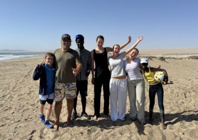 group of employees with children on a beach in Namibia