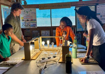 intern with three children doing a project with lightbulbs