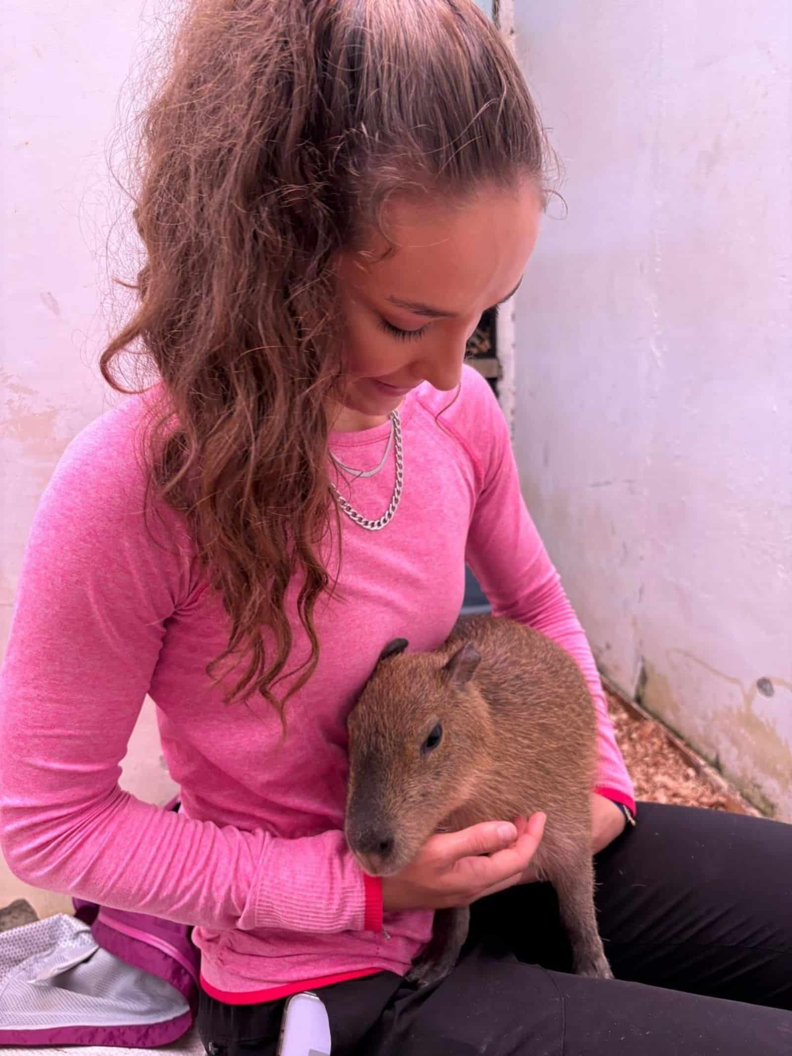 Carly holding capybara at wildlife rescue project in Ecuador