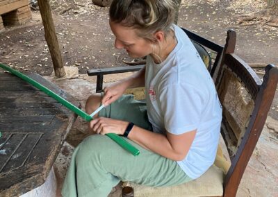 Volunteer cutting a plastic tube.